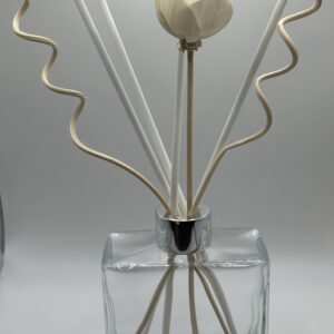 A reed diffuser with a unique zigzag design in a glass bottle.