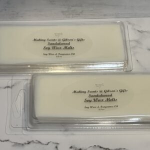 Two soap bars labeled with a personalized name and date on a marble surface.
