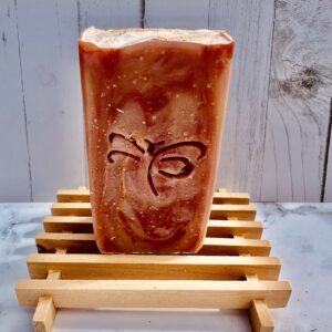 Handcrafted ceramic cup with a butterfly design on a wooden stand.