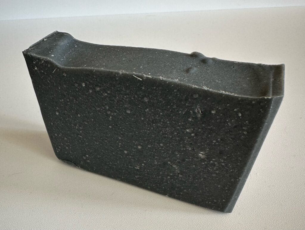 Black rectangular block with a textured surface.