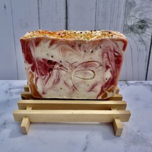 A loaf of marbled bread with red and white swirls on a wooden stand.