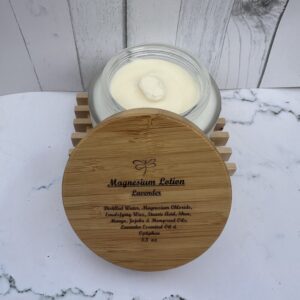 Jar of organic turmeric lotion with wooden lid on a white surface.