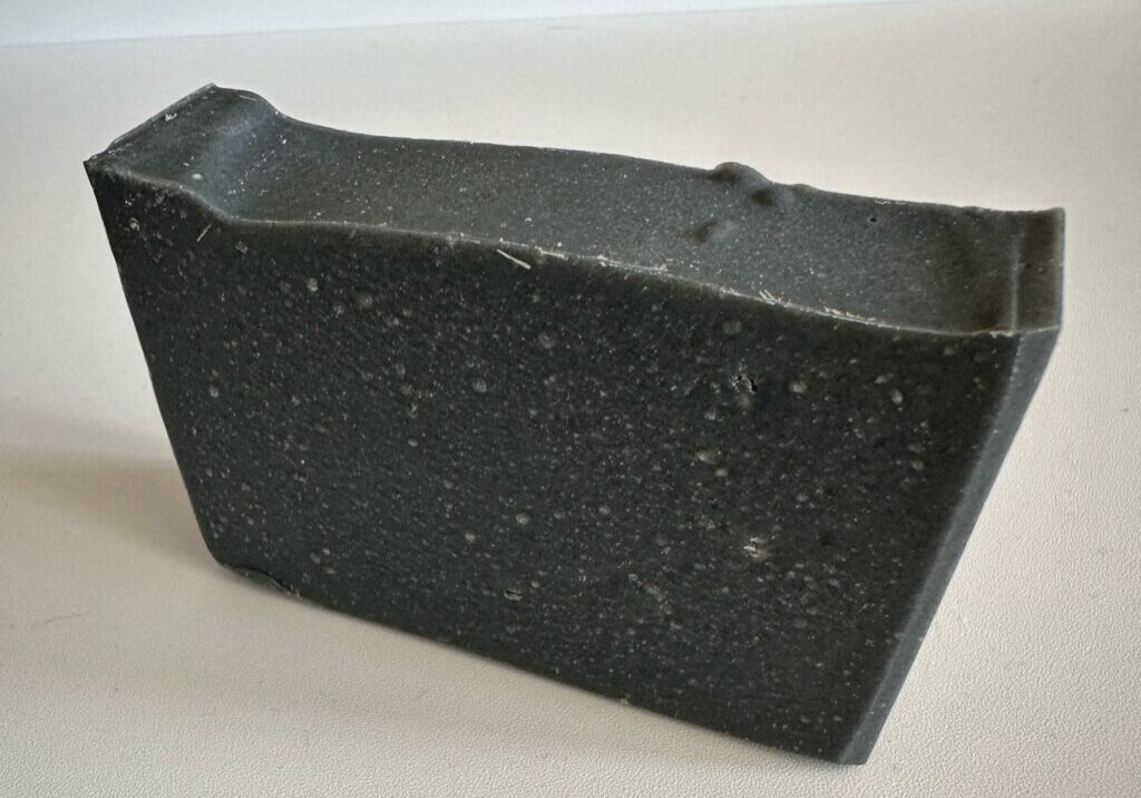 Black rectangular block with a textured surface.